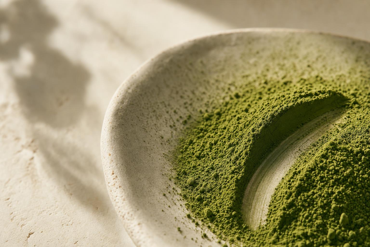 Fine matcha powder macro on cream ceramic